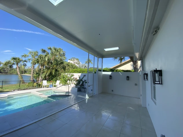 Modern outdoor patio featuring durable insulated aluminum panels, installed by AlumiPro, providing shade and energy efficiency by the poolside.